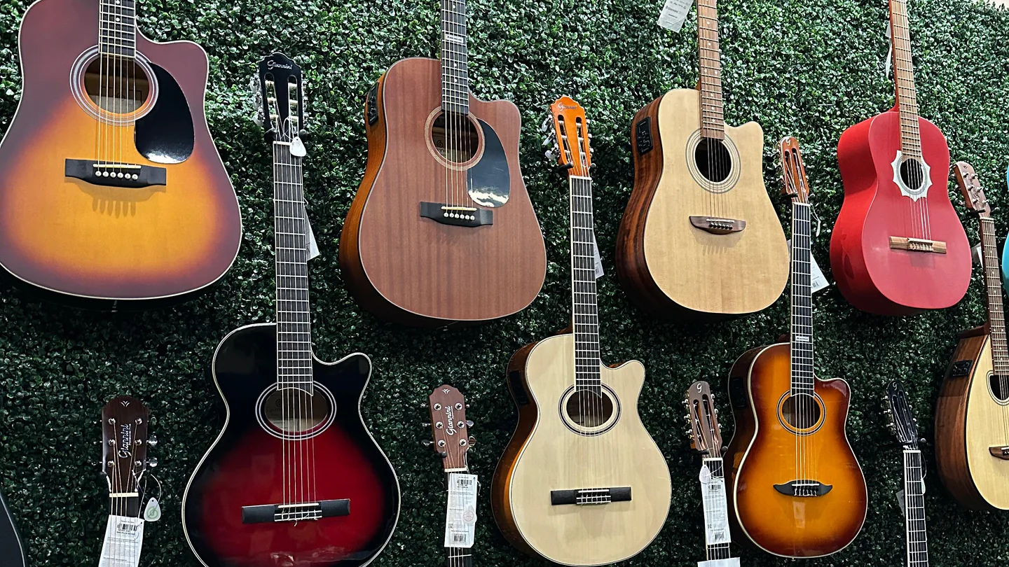 Parede de violões e guitarras no showroom da MdAyres Music